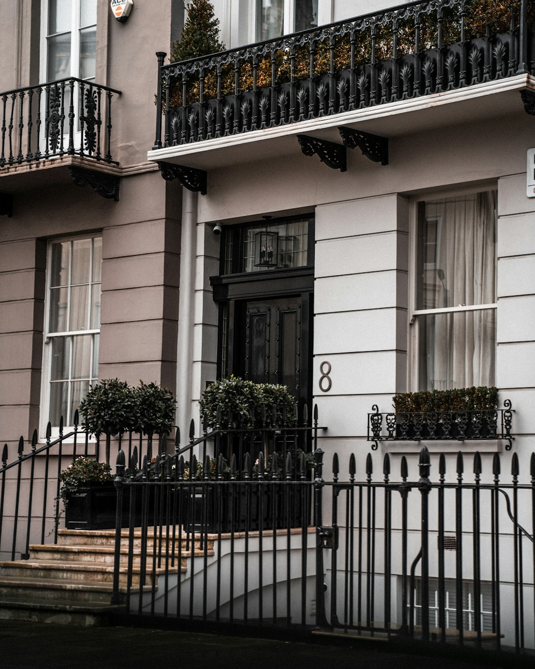 An elegant white London townhouse with black railings, of the type managed by PMN